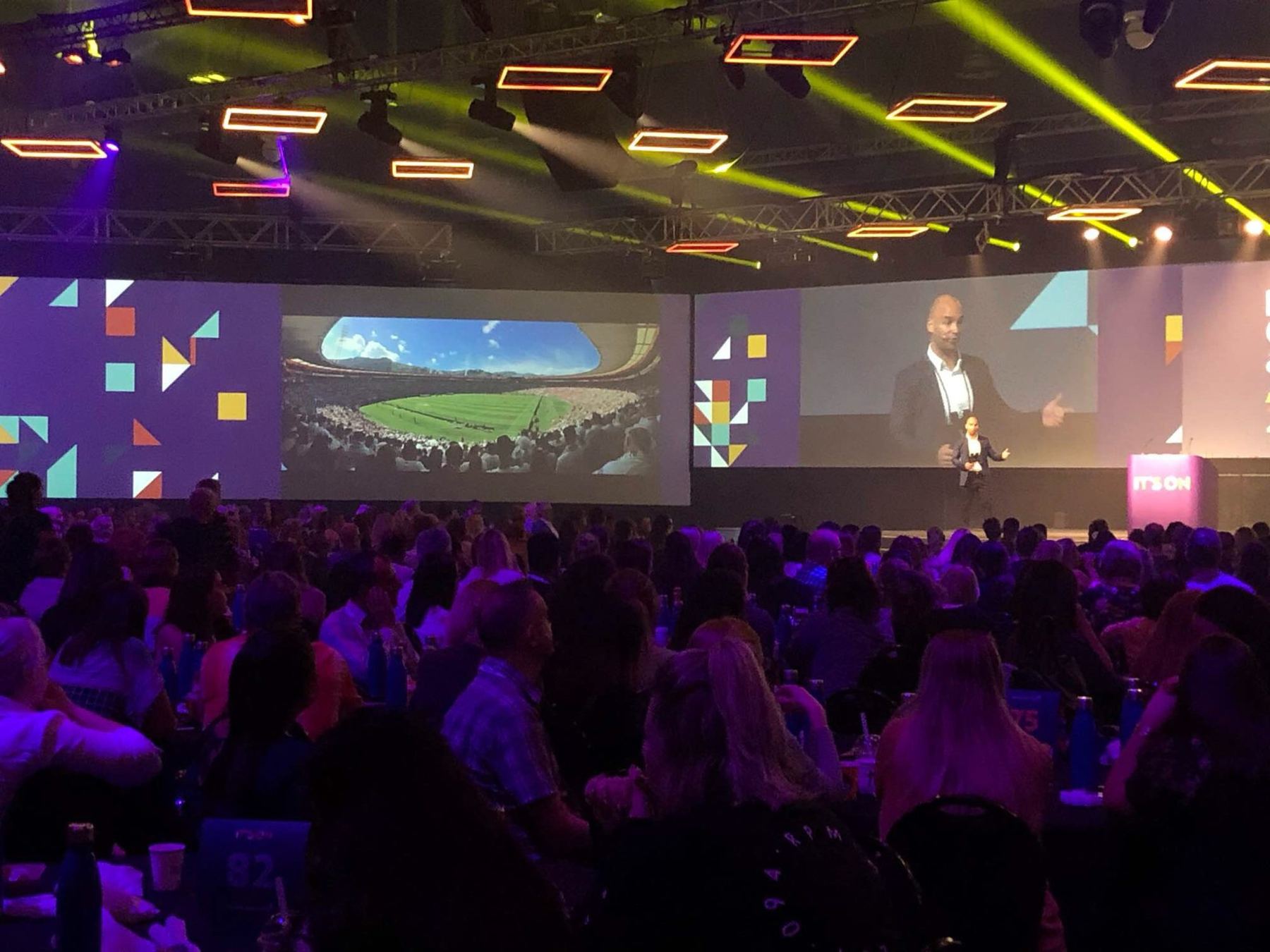 A packed conference hall watching Joel on stage