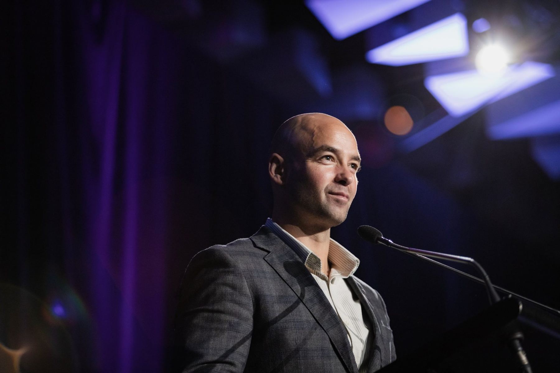 Joel Bouzaid speaking at a lectern under stage lights